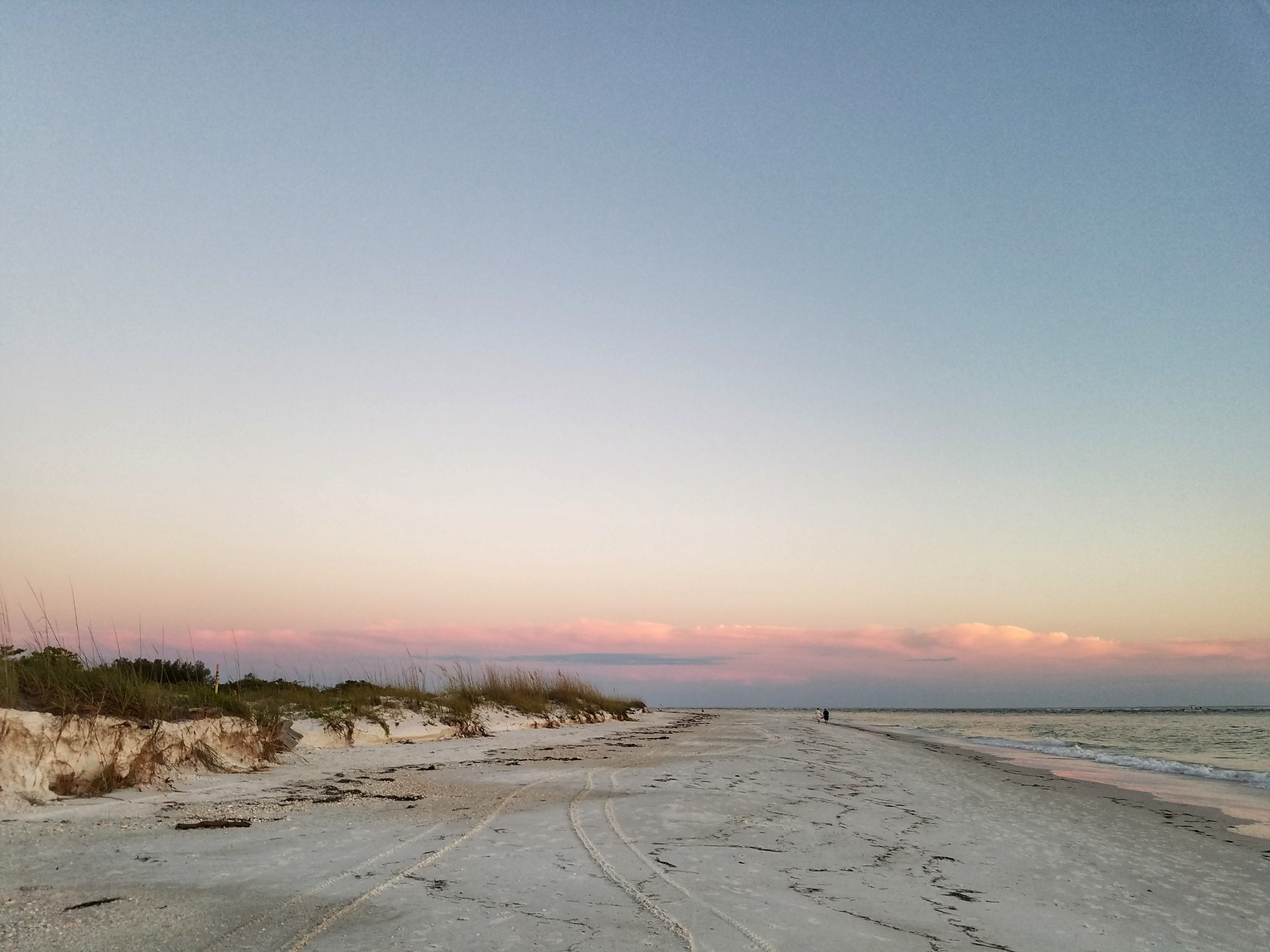 White sand beach on Lido Key with pink clouds at sunset in Sarasota, Florida
