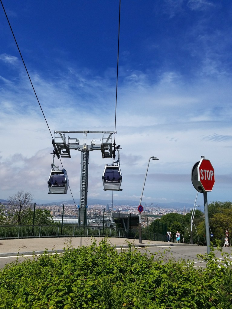 Cable cars crossing over a stop sign in Barcelona Spain