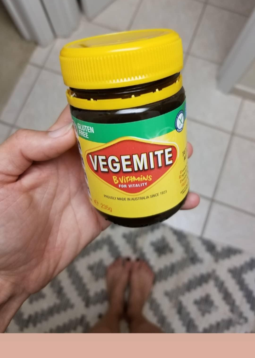 Hand holding a jar of Vegemite
